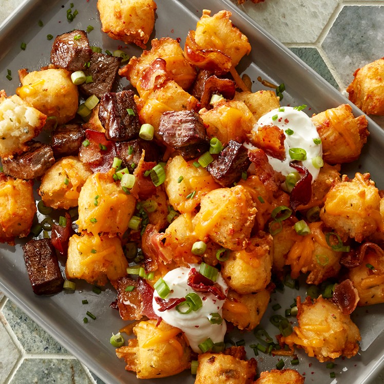 https://www.usfoods.com/content/usfoods-dce/en/great-food/recipes/totchos--featuring-cheddar-sour-cream-and-chive-potato-tots-/_jcr_content/recipe-header/image.img.jpg/1676918916276.jpg